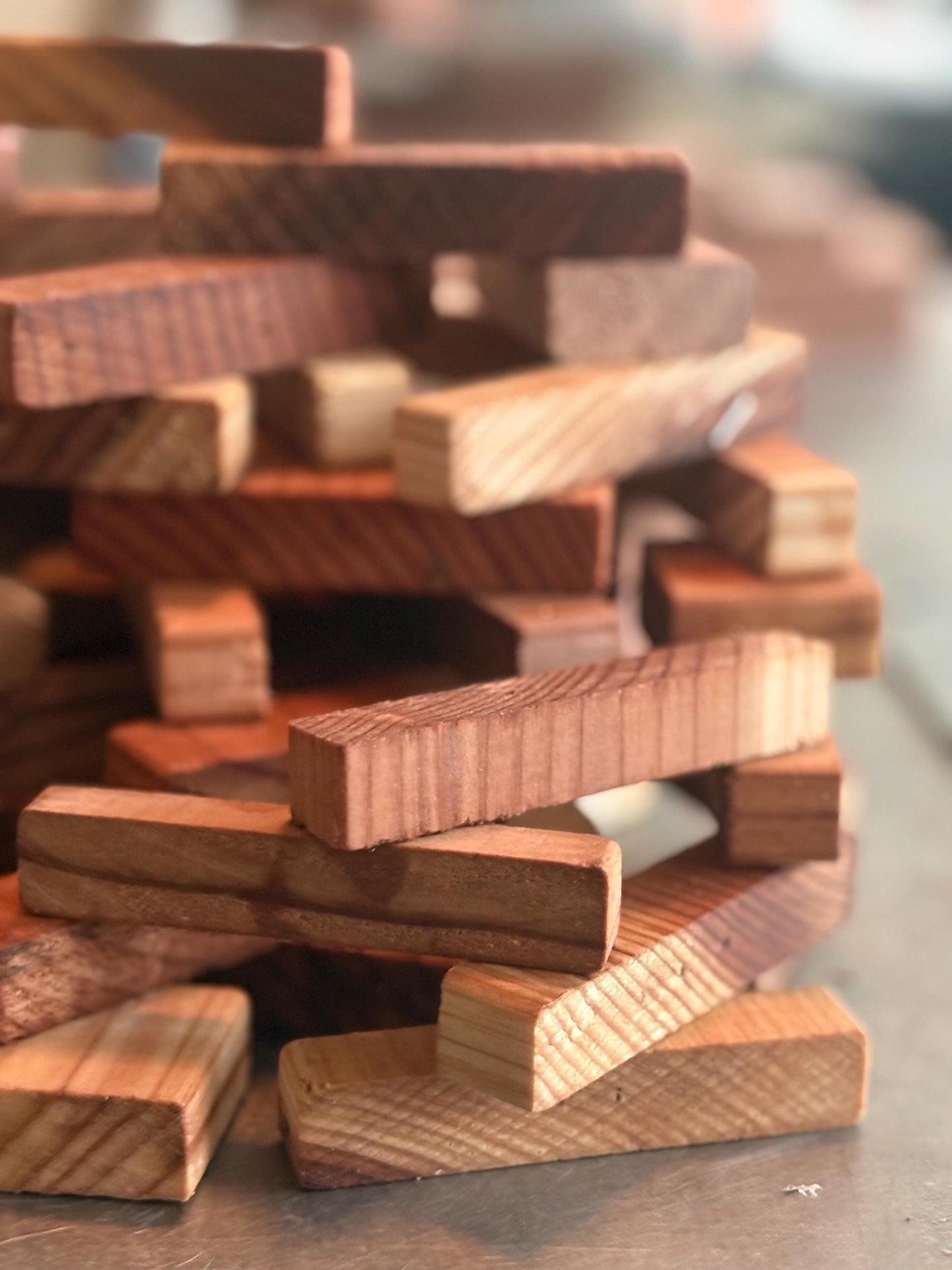 Stack of small redwood wood pieces showing natural grain and texture from workshop offcuts.