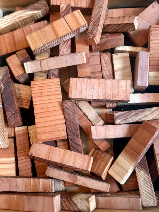 Assorted redwood wood offcuts and small craft blocks used for compost bins, crafts, and garden projects.